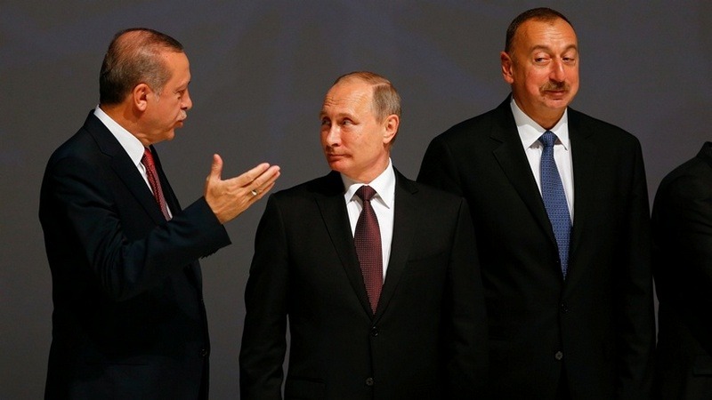Turkish President Erdogan chats with his Russian counterpart Putin as Azeri President Aliyev watches during the 23rd World Energy Conress in Istanbul